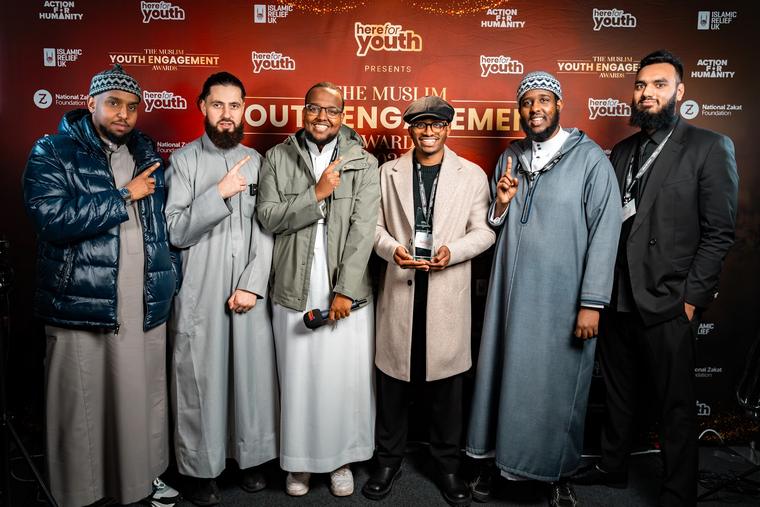 Award recipients photographed in front of the ceremony backdrop.
